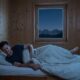 Person struggling to sleep at high altitude in Denver bedroom